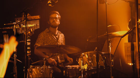 a man playing the drums, orange tint