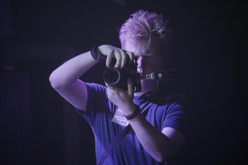 man holds camera, blue tint